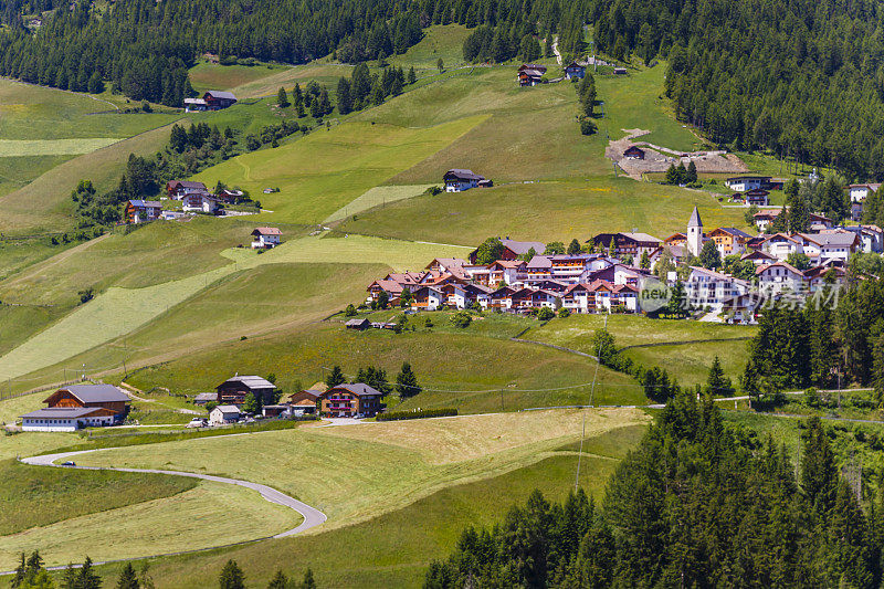 村庄在田园诗白云石阿尔卑斯风景- Val Gardena，意大利